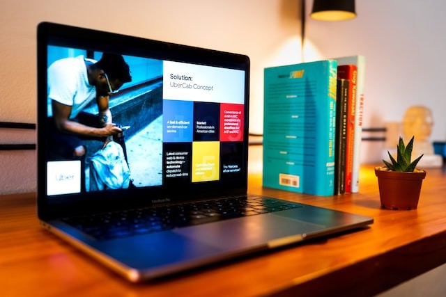 black laptop on brown wooden table